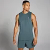 Een man draagt een donkerleigrijs trainingshemd zonder mouwen en bijpassende korte broek.