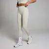 Een asgrijze, naadloze legging met hoge taille, gedragen door een persoon met witte sokken en sportschoenen.
