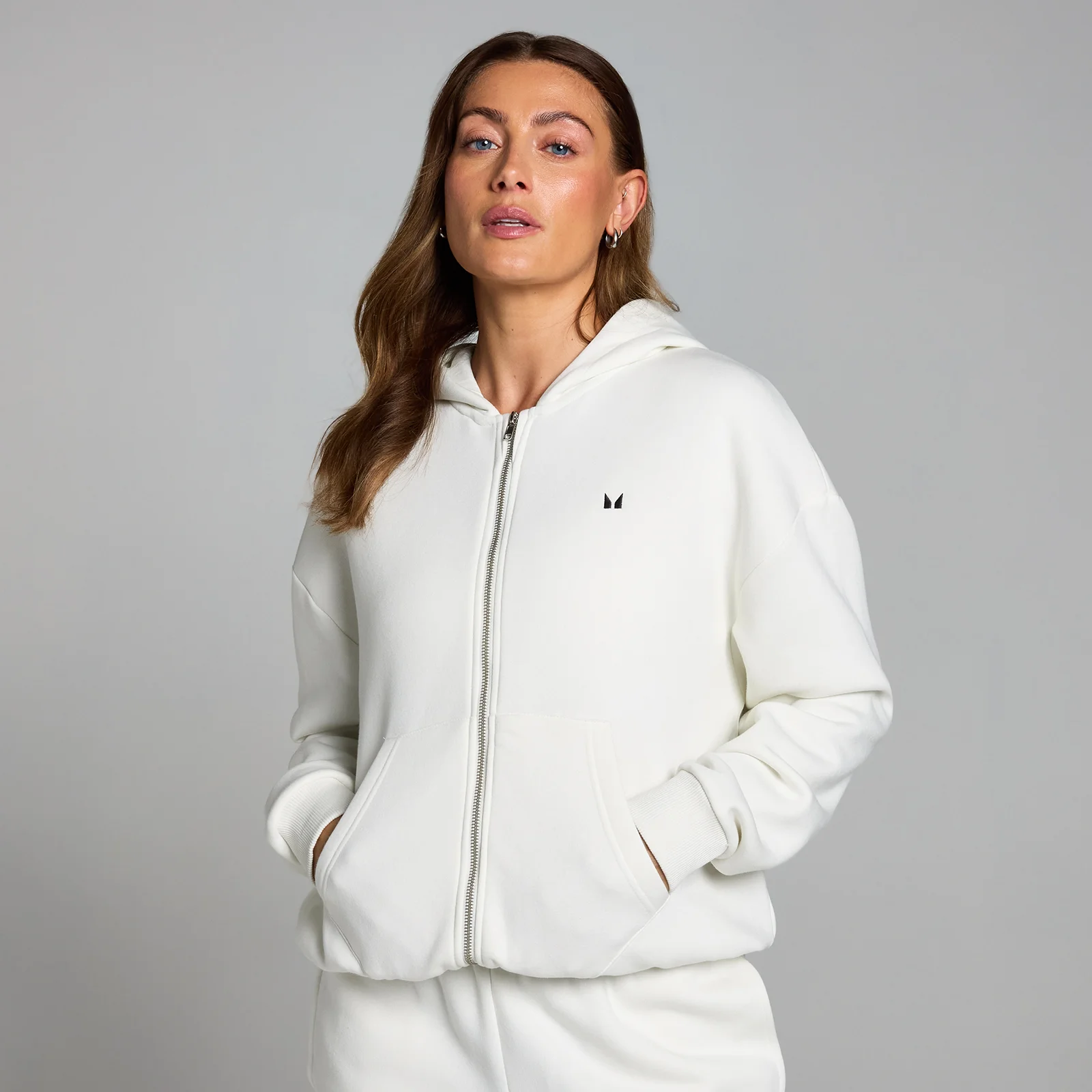 Een vrouw draagt een wolkenblauwe MP hoodie met rits en zakken.