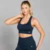 Een vrouw draagt een donker saffierrode naadloze sportbeha en bijpassende legging van Myprotein.