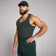 Een man draagt een mouwloze, geribbelde, donkergrijze tanktop en een groene pet en broek.