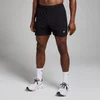Een man draagt een zwarte trainingsshort met een elastische tailleband en een klein logo.
