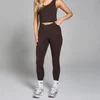 Een vrouw draagt een cacaobruine legging en bijpassende top van Myprotein.