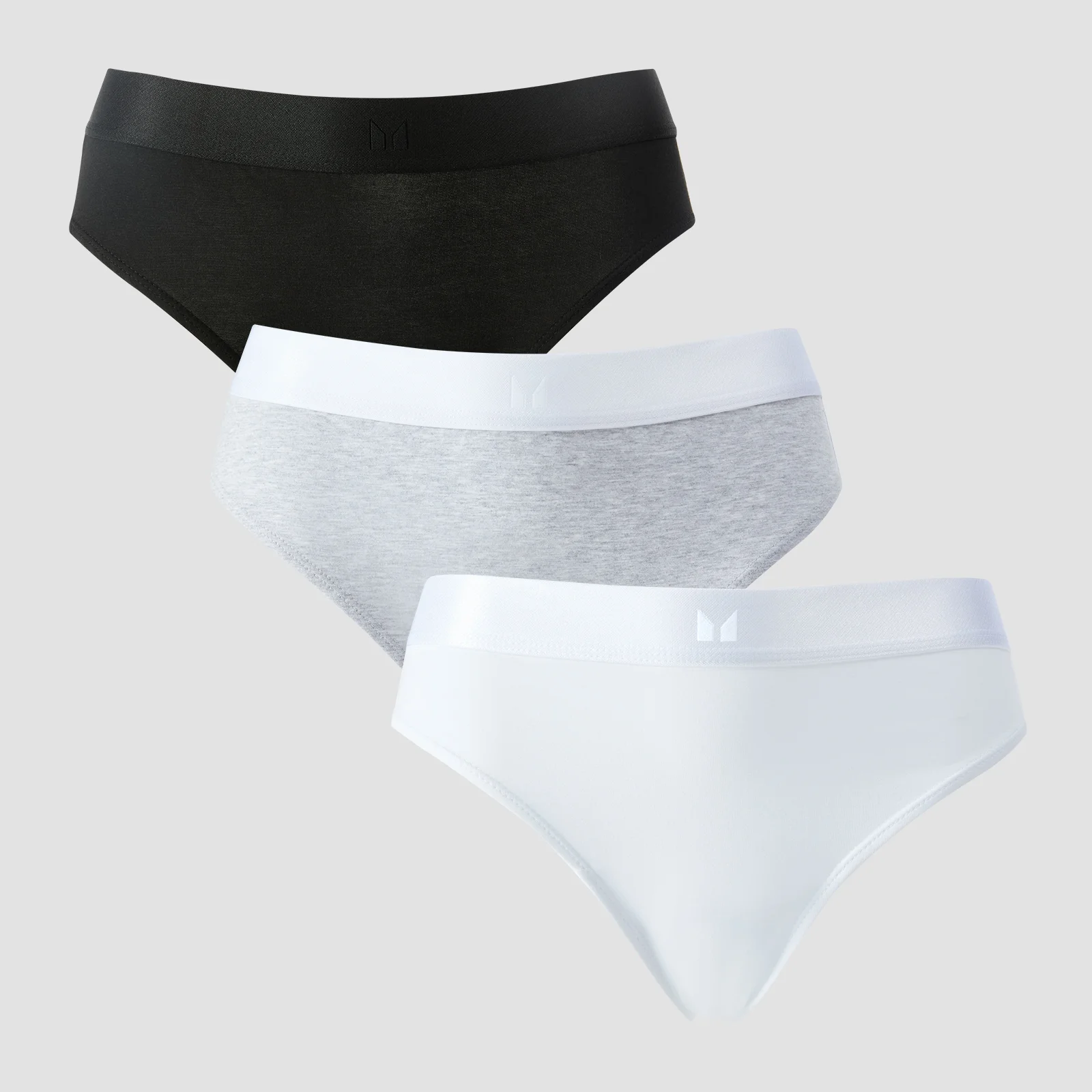 Drie bikinibroekjes: zwart, grijs gemêleerd met witte band, en wit met witte band.