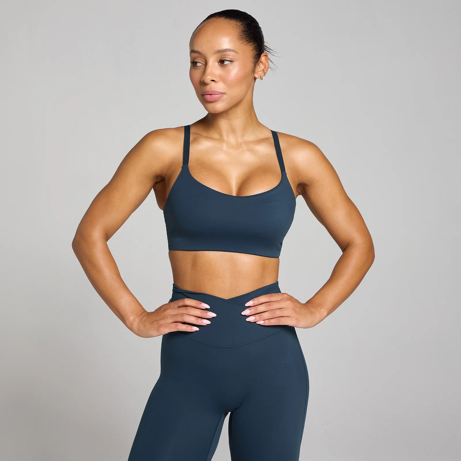 Een vrouw draagt een donker saffierblauwe sportbeha en legging van Myprotein.