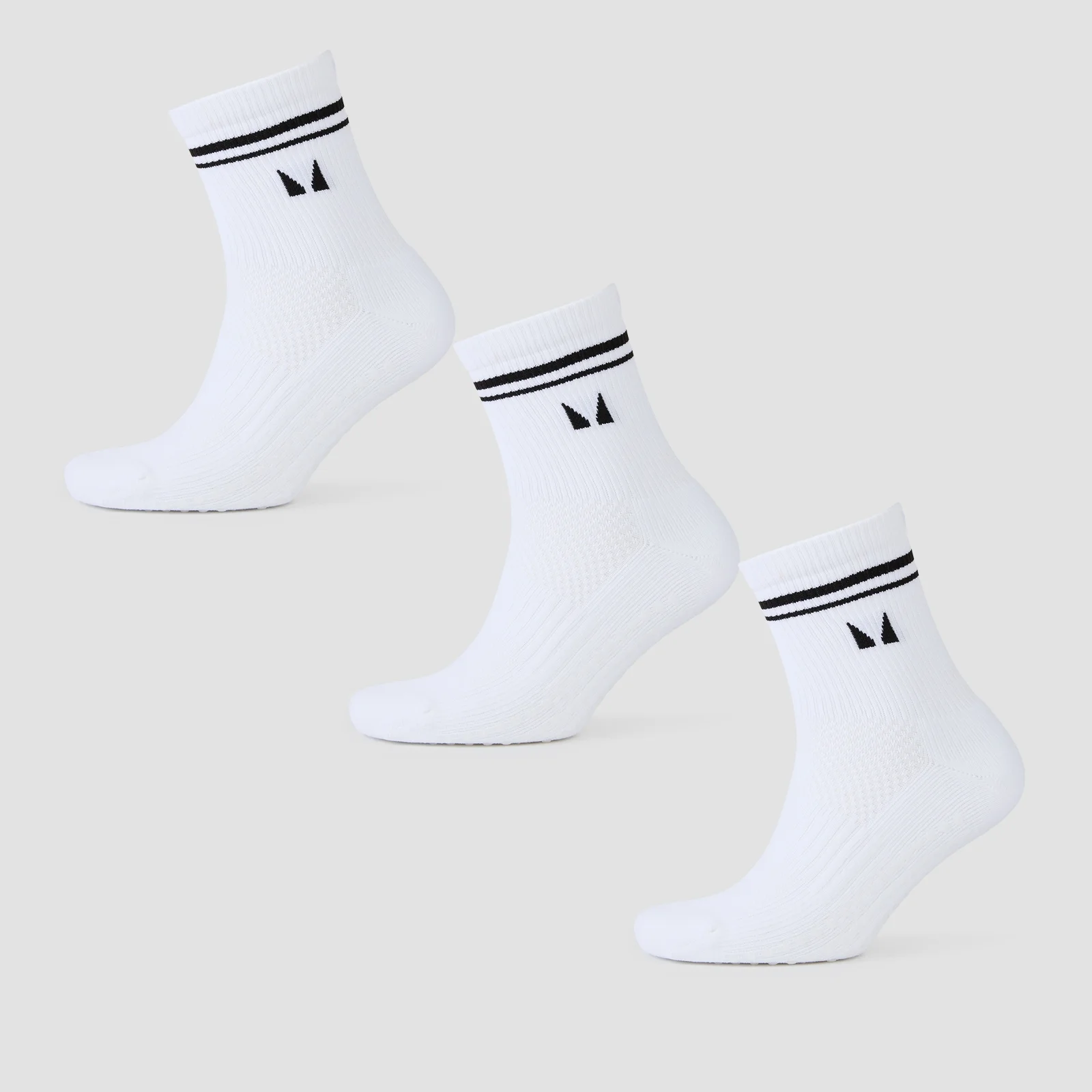 Drie witte sokken met zwarte strepen aan de bovenkant en een klein zwart logo.