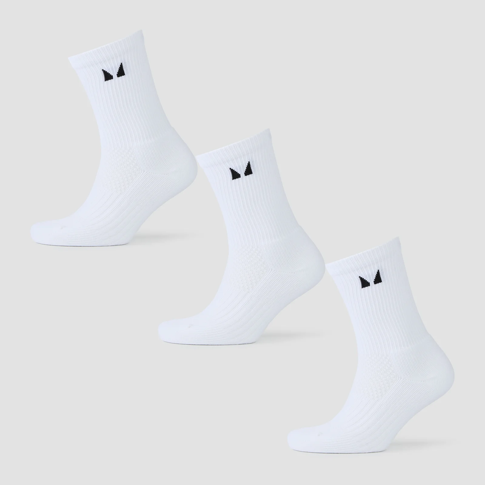 Drie witte, halflange sokken met een zwart logo, liggend op een grijze achtergrond.