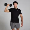 Een man draagt een zwart T-shirt met korte mouwen en een klein logo, en grijze sportshorts.