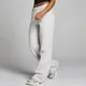 Een vrouw draagt een gemêleerde grijze joggingbroek met rechte pijpen en een elastische tailleband.