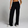 Een vrouw draagt een zwarte joggingbroek met rechte pijpen en een klein wit logo.