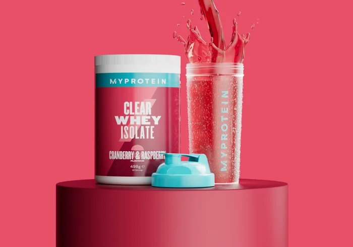 De clear protein starter pack op een podium in de smaak cranberry & framboos, naast een shaker van het Myprotein-merk.